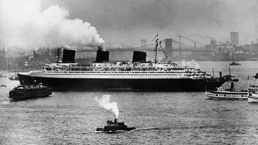 1932 yılında Saint-Nazaire'de inşa edilen lüks okyanus gemisi SS Normandie, yaklaşık on yıl boyunca Fransa'nın gururu oldu. 9 Şubat 1942'de Manhattan limanında, bu ihtişamlı rüya birkaç saat içinde duman olup uçtu. Neredeyse bir asır sonra, bunun bir saldırı olduğu yönündeki teori hala geçerliliğini koruyor.
Bu belgesel, komplo teorilerinin ve söylentilerin henüz "yalan haber" olarak adlandırılmadığı zamanlarda az bilinen tarihi bir olaya geri dönüyor. Resmi soruşturma, bunun feci bir kaza olduğu sonucuna vardı. Ancak yabancı, casus ve sabotajcı korkusunun gerçekle kurgu arasındaki çizgiyi bulanıklaştırdığı kolektif paranoya ortamında, SS Normandie'nin enkazı bütün bir ülkenin kabuslarının odak noktası haline geldi.
